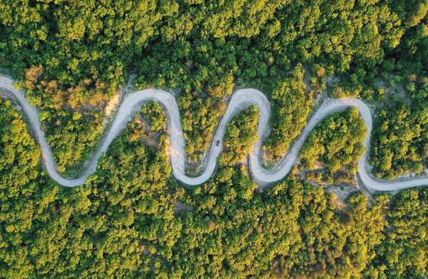 Дорожное путешествие, машина едет по кривой дороге
.