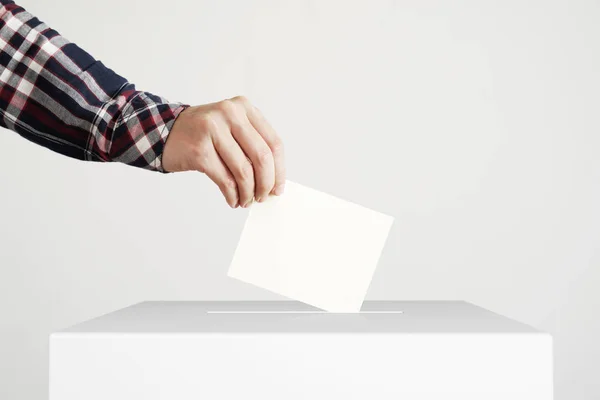 Mann wirft Stimmzettel in Wahlurne. — Stockfoto