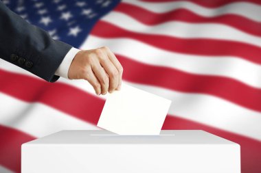 Adam oy sandığına Amerikan bayrağını koyuyor.