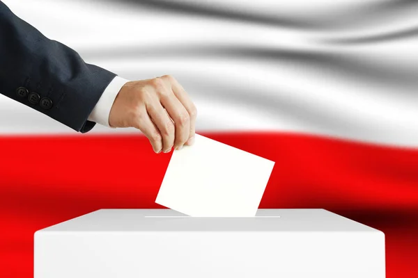 Verkiezing in Polen. Man die een stembiljet in een stembus stopt. — Stockfoto