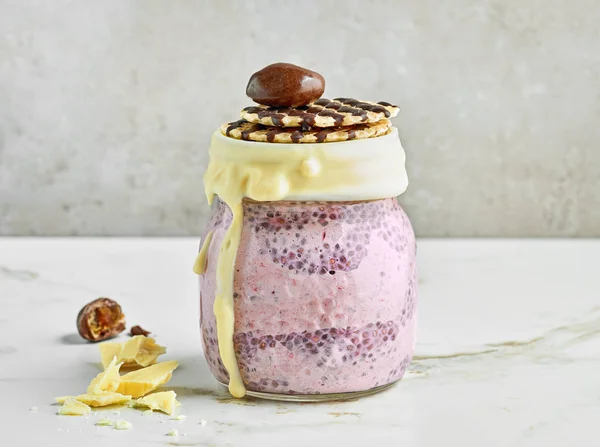 dessert of chia pudding with frozen banana and blackberries decorated with melted white chocolate