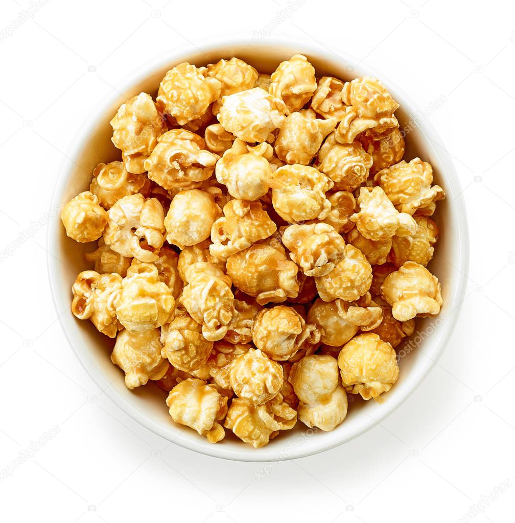 bowl of caramel popcorn isolated on white background, top view