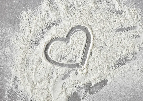 Heart shape in flour on grey kitchen table — Stock Photo, Image