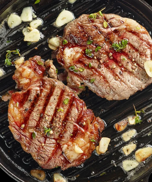 Grilled steaks on grilling pan — Stock Photo, Image