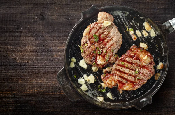 Grilled steaks on grilling pan — Stock Photo, Image