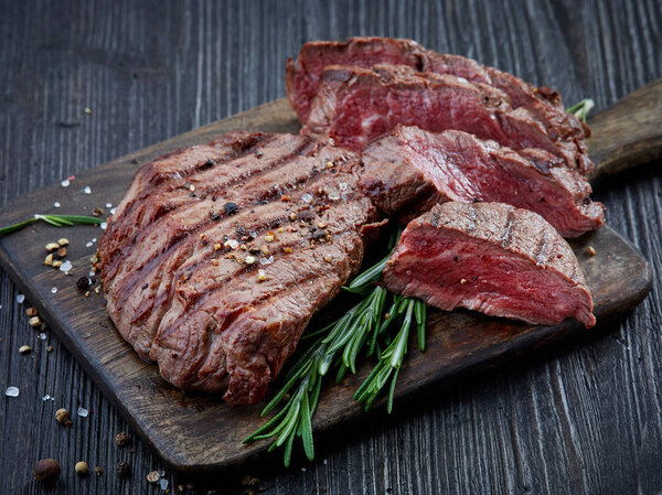 Grilled beef fillet steak meat on dark wooden table