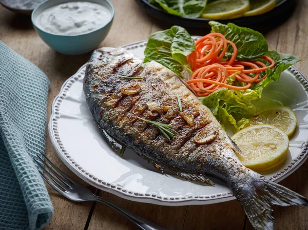 Peixe grelhado na mesa de cozinha de madeira — Fotografia de Stock