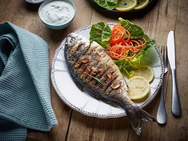 Риба на грилі на дерев'яному кухонному столі — стокове фото