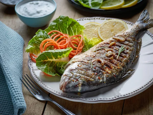 Grilled fish on wooden kitchen table — Stock Photo, Image