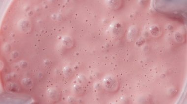 Çilekli ve muzlu, pembe milkshake karışımı. Üst Manzara. Ağır çekim. Sağlıklı protein smoothie içecek konsepti, yiyecek yakın çekim