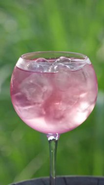 Bir bardak taze ahududu sprey kokteyli yeşil arka bahçe arka planına karşı, güneşli güzel bir yaz günü