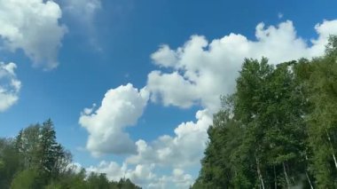 Güzel beyaz bulutlar mavi gökyüzünde Sürücü bir arabanın camından