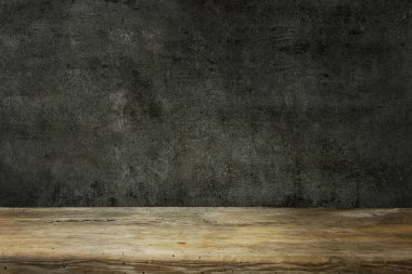 Tahta masa ve koyu siyah duvar.