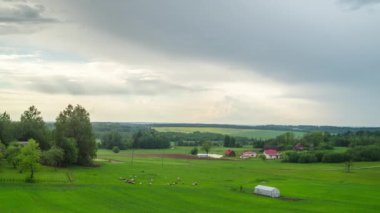 Yağmur bulutları ve otlatma koyun ile kırsal peyzaj, zaman atlamalı
