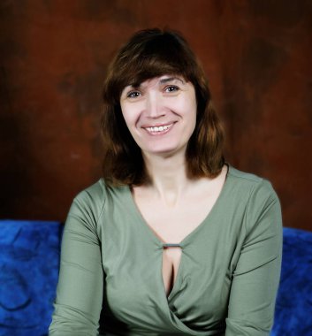 gülümseyen bir sandalyede oturan orta yaşlı kadın