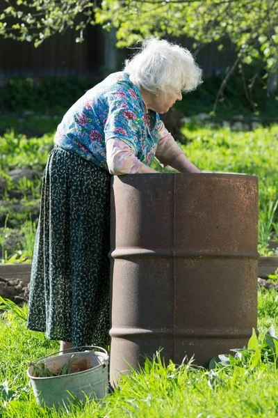 Alte Frau Garten Einem Eisernen Fass Mit Wasser — Stockfoto