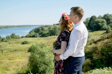 kız ve erkek bir yaz günü nehrin yüksek bir kıyısında sarılma