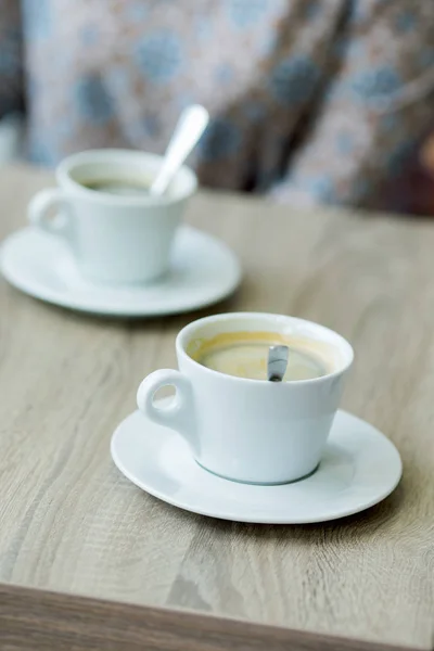 Cup of coffee on a table in a cafe close-up with shallow depth o — Stock Photo, Image