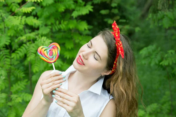 Mädchen mit einem Lutscher in den Bäumen am Sommertag — Stockfoto