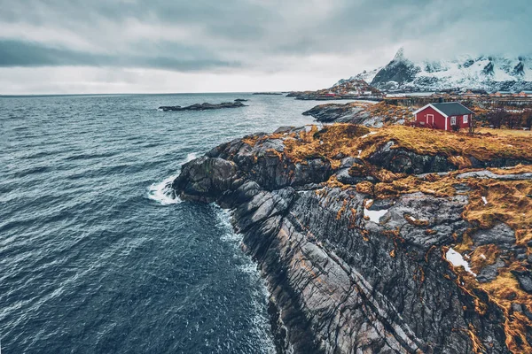 Clif met traditionele rode rorbu huis op de Lofoten eilanden, Noorwegen — Stockfoto