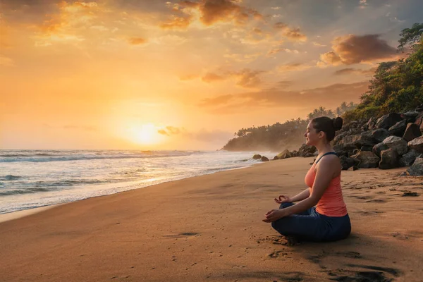 Vrouw doet yoga op strand - Padmasana lotus pose — Stockfoto