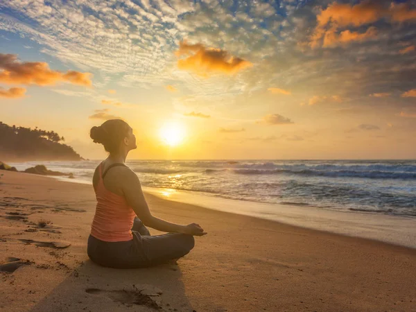 Vrouw doet yoga oudoors op strand - Padmasana lotus pose — Stockfoto