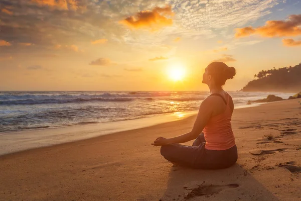 Mujer haciendo yoga al aire libre en la playa - Padmasana pose de loto — Foto de Stock