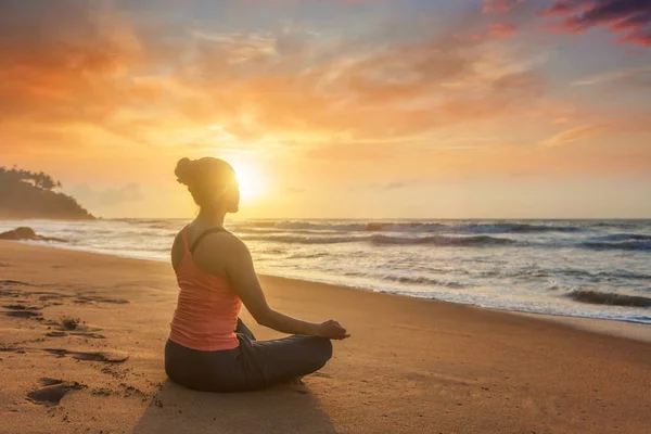 Vrouw doet yoga oudoors op strand - Padmasana lotus pose — Stockfoto