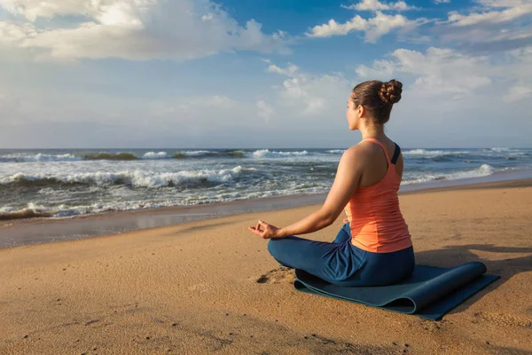 Vrouw doet yoga Lotus pose oudoors op strand — Stockfoto