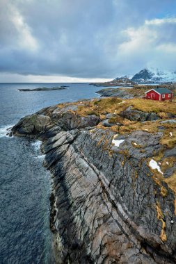 Clif ile geleneksel kırmızı rorbu ev Lofoten Adaları, Norveç