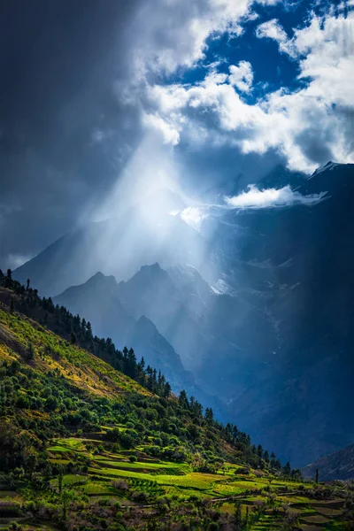 Solen strålar igenom molnen i Himalayas dalen i Himalaya — Stockfoto