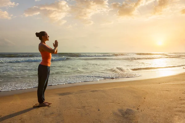 Kumsalda yoga yapan bir kadın. — Stok fotoğraf