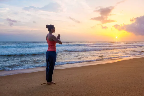 Kumsalda yoga yapan bir kadın. — Stok fotoğraf