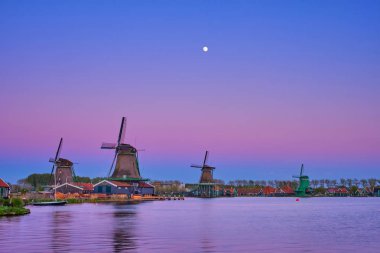 Hollanda Zaanse Schans 'daki yel değirmenleri gün batımında alacakaranlıkta. Zaa