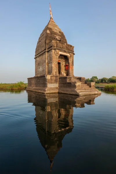 Маленький индуистский храм в середине святой реки Нармада, Махешвар, штат Мадхья-Прадеш, Индия — стоковое фото
