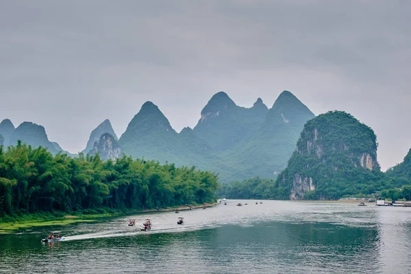 Туристические лодки на реке Ли с карстовыми горами на заднем плане — стоковое фото