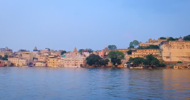 Udaipur City ghat Lal ghat och Udaipur City Palace panoramautsikt från sjön Pichola. Rajput arkitektur Mewar dynastin härskare i Rajasthan. Udaipur, Indien — Stockvideo