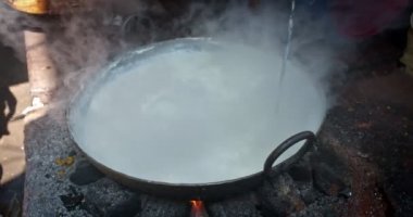 Hint sokak yemekleri: Hindistan 'ın Pushkar şehrinde pazarda kaynamış tatlı süt keki pişirmek. Hint tatlıları mawa. Sütü azaltarak elde edilen peynir Mawa olarak bilinir. Rajasthan, Batı Hindistan