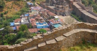 Kumbhalgarh kalesi ve Hint şehri Kumbhalgarh hava manzarası. Surlar - Aravalli tepelerindeki kale antik duvarlar ünlü bir turizm merkezidir. Rajasthan 'daki Hill Kalesi' ne ait. Hindistan. Kamera yukarı hareket ediyor