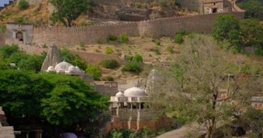 Turistler tarihi Hint Kumbhalgarh kalesini ziyaret ettiler. Yeşil Aravalli tepelerindeki eski kale antik duvarları ünlü bir turizm merkezidir. Rajasthan 'daki Hill Kalesi' ne ait. Hindistan. Kamera yukarı hareket ediyor