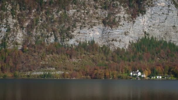 山の中の有名な観光地穏やかな町ホルスト秋にアルプス 高い丘の上の木の上の大聖堂の教会 地元の家 黄金の葉は湖の水に反映されます オーストリア — ストック動画