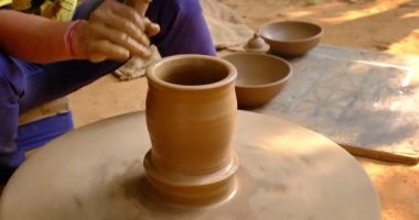 Çömlekçi - çömlekçinin becerikli ıslak elleri çömlekçi çarkındaki çamuru şekillendiriyor. Esrar, vazo fırlatma. Geleneksel el işi Hint kâsesi, kavanoz, esrar, sürahi üretiyor. Shilpagram, Udaipur, Rajasthan, Hindistan