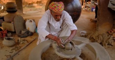 Hintli çömlekçi: çömlekçi çarkını fırlatmak ve seramik kap ve kil kapları şekillendirmek: çömlek atölyesinde kap, kavanoz. Tecrübeli usta. Shilpagram, Udaipur, Rajasthan, Hindistan 'dan el işi.