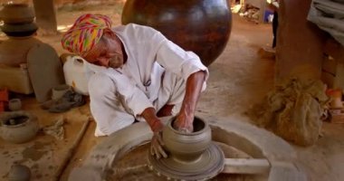 Hintli çömlekçi: çömlekçi çarkını fırlatmak ve seramik kap ve kil kapları şekillendirmek: çömlek atölyesinde kap, kavanoz. Tecrübeli usta. Shilpagram, Udaipur, Rajasthan, Hindistan 'dan el işi.