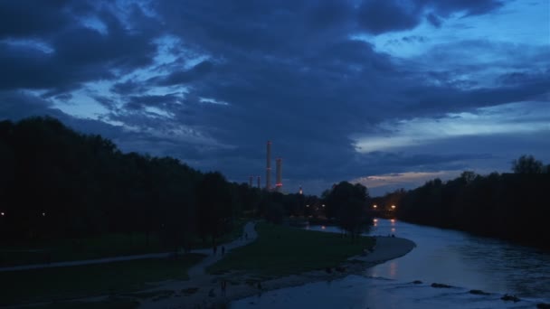 劇的な夕暮れ時のミュンヘンの自然 バイエルン州の観光都市の公園で秋 ライヘンバッハ橋からイシャー川 聖マクシミリアン教会の眺め ドイツのバイエルン州ミュンヘン カメラ水平パン — ストック動画