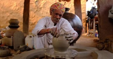 Hintli çömlekçi: çömlekçi çarkını fırlatmak ve seramik kap ve kil kapları şekillendirmek: çömlek atölyesinde kap, kavanoz. Tecrübeli usta. Shilpagram, Udaipur, Rajasthan, Hindistan 'dan el işi.
