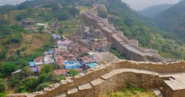 Kumbhalgarh kalesi ve Hint şehri Kumbhalgarh hava manzarası. Surlar - Aravalli tepelerindeki kale antik duvarlar ünlü bir turizm merkezidir. Rajasthan 'daki Hill Kalesi' ne ait. Hindistan. Kamera yukarı hareket ediyor