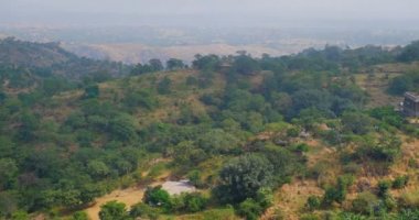Kumbhalgarh kalesi ve Hint şehri Kumbhalgarh hava manzarası. Ağaçlar ve kaleler Aravalli tepelerindeki antik duvarlar ünlü bir turizm merkezidir. Rajasthan 'daki Hill Kalesi' ne ait. Hindistan