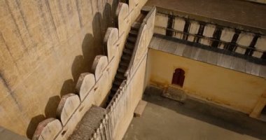 Tarihi Hint Kumbhalgarh kalesinin dizaynına sahip duvar. Eski kale antik duvar ve yeşil Aravalli tepeleri. Rajasthan 'daki Hill Kalesi' ne ait. Hindistan. Kamera yukarı hareket ediyor
