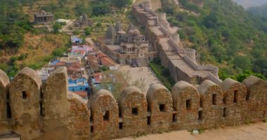 Kumbhalgarh kalesi ve Hint şehri Kumbhalgarh hava manzarası. Surlar - Aravalli tepelerindeki kale antik duvarlar ünlü bir turizm merkezidir. Rajasthan 'daki Hill Kalesi' ne ait. Hindistan. Kamera yukarı hareket ediyor
